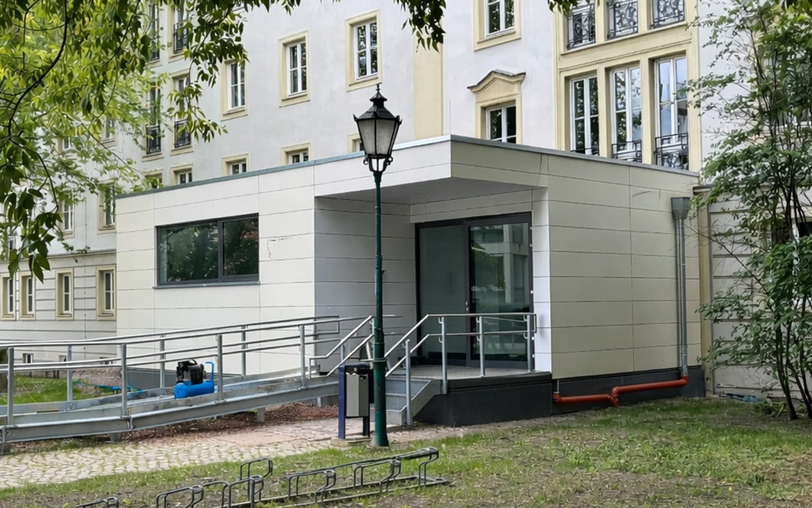 Moderner Anbau mit barrierefreier Rampe am Zugang eines denkmalgeschützten Bestandsgebäudes